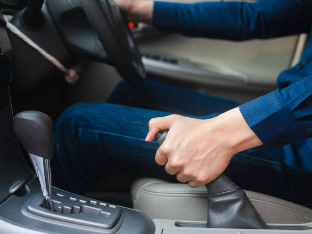 istock driver's hand pulling the hand brake in a car 1133609066