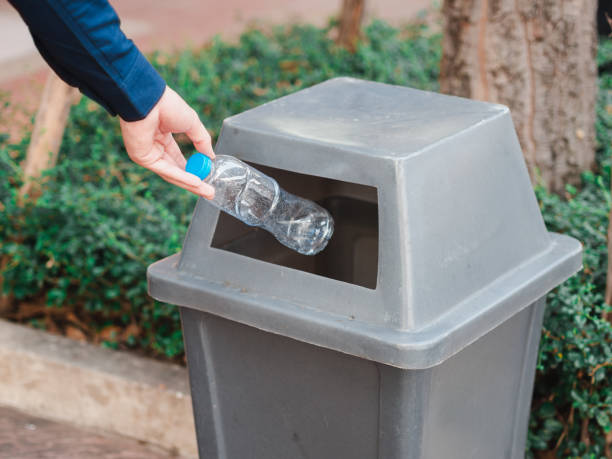 istock Closeup of man hand throwing empty plastic water bottle in a bin. 1133609209