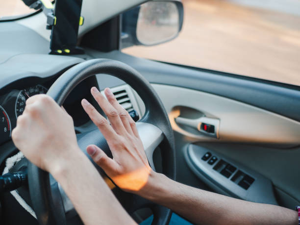 istock Closeup Driver's hand pressing on a car horn while driving 1133609213