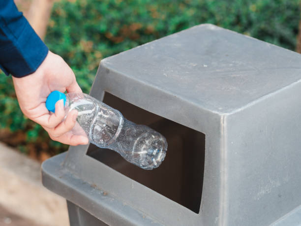 istock Closeup of man hand throwing empty plastic water bottle in a bin. 1133609243