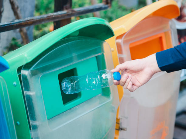 istock Closeup of man hand throwing empty plastic water bottle in recycling bin. 1133609326