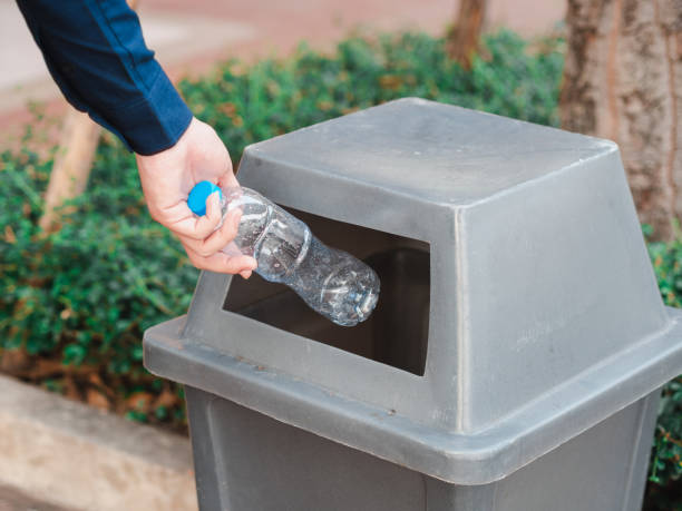 istock Closeup of man hand throwing empty plastic water bottle in a bin. 1133609612
