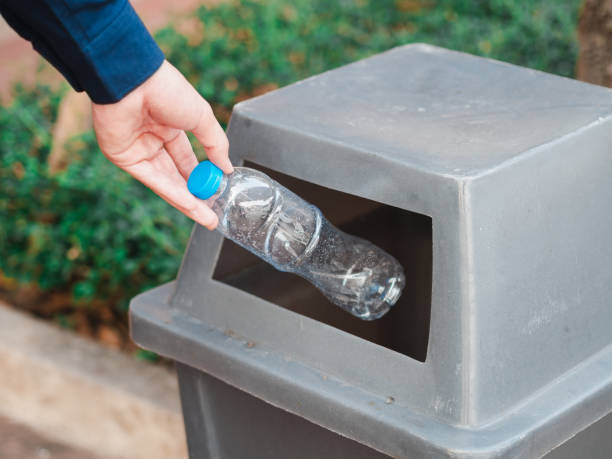 istock Closeup of man hand throwing empty plastic water bottle in a bin. 1133609614