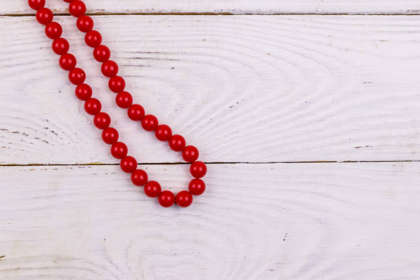 istock Red beads necklace on white wooden background. Top view 1133610954