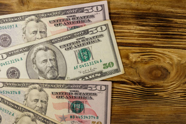 istock Fifty dollars banknotes on wooden background. Top view 1133611996