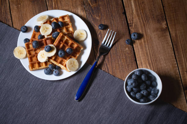 Fresh homemade belgian waffles with blueberries and banana for breakfast