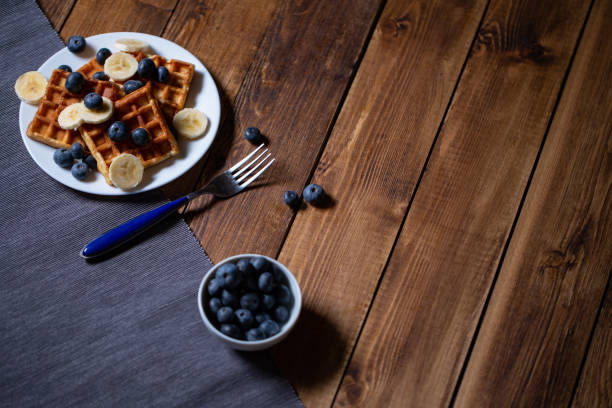 Fresh homemade belgian waffles with blueberries and banana for breakfast