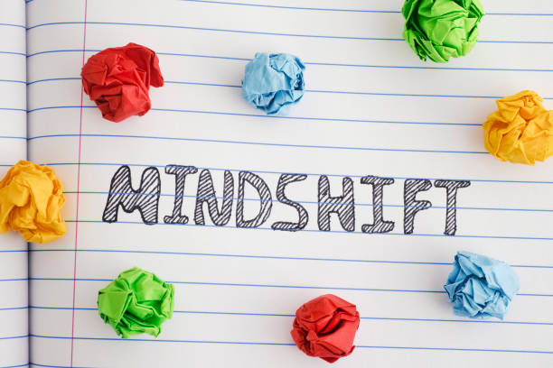 istock Word Mindshift on notebook sheet with some colorful crumpled paper balls around it 1133614913