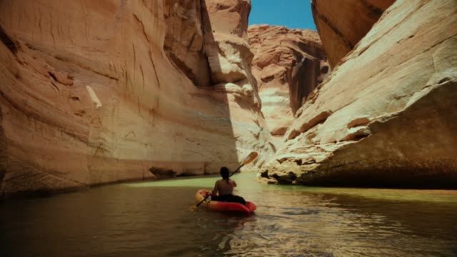 Woman kayaking in canyons of Powell lake recreational area