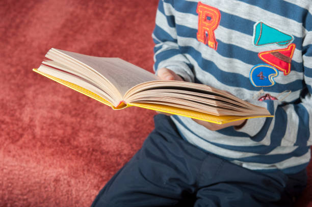 istock Kid with book at home. 1133616951