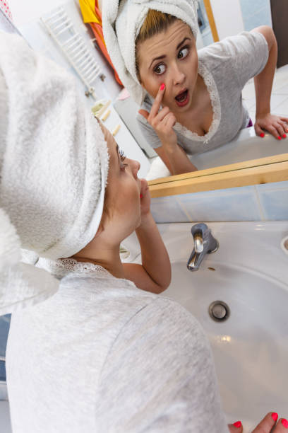 istock Woman looking at her reflection in mirror 1133618384