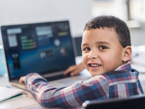 istock Smiling black business boy using laptop in the office. 1133620273