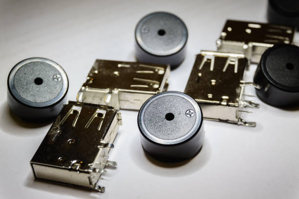 istock Close-up of scattered USB socket and buzzer electronics components on white background in partial focus and random pattern 1133621933