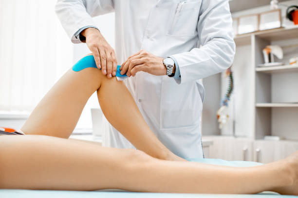 istock Therapist applying kinesio tape on a woman's knee 1133629917