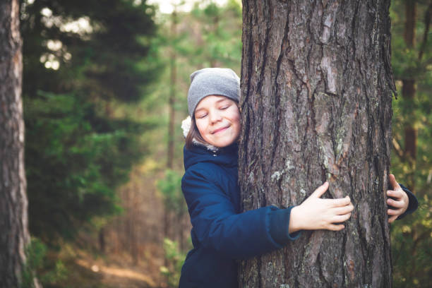 Boy hugging the tree Little boy hugging the trunk of a big tree hugging tree stock pictures, royalty-free photos & images