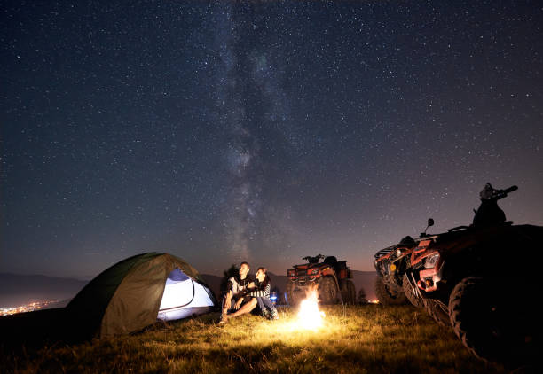 coppia turisti con quad atv sotto notte cielo stellato - off road vehicle quadbike 4x4 adventure foto e immagini stock