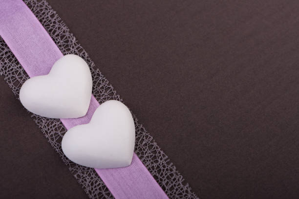 two white hearts made of plaster connected with bow,