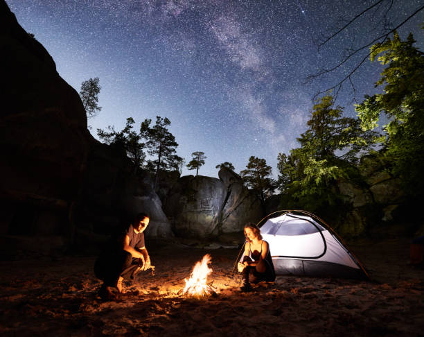 istock Couple tourists resting beside camp, campfire tent at night 1133636043