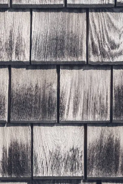 Gray wooden tiles texture. Detail of a rustic house wall.