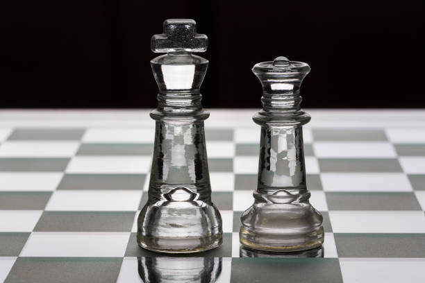istock King and queen glass chess pieces facing each other in black and white 1133636184