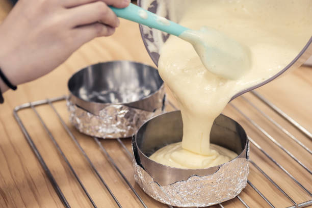 istock Woman's hands pouring cake batter into cake mold, ready to bake. 1133637778
