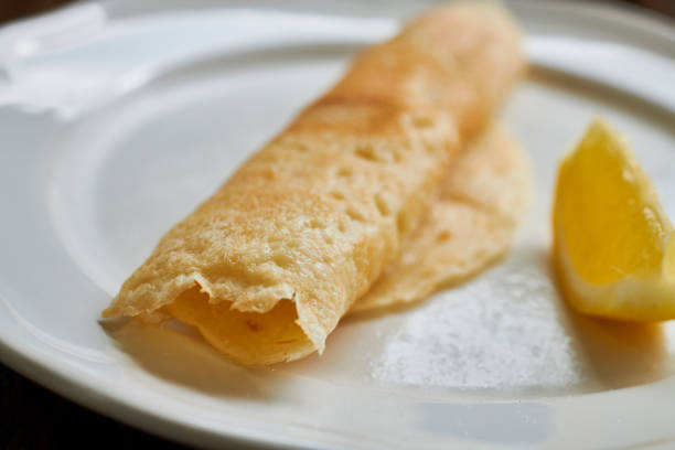 istock Rolled Pancake on a plate with a wedge of lemon. 1133639951