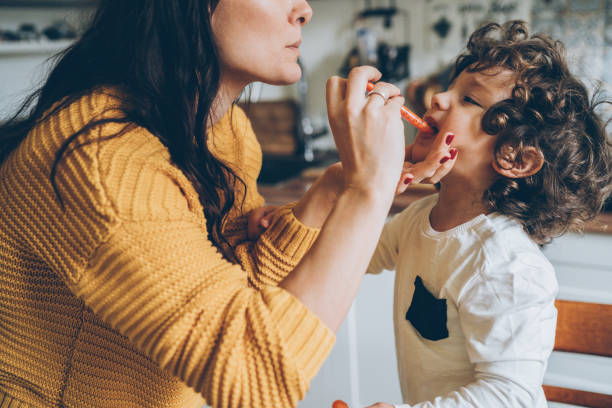 istock Mother giving syrup to her son 1133643264