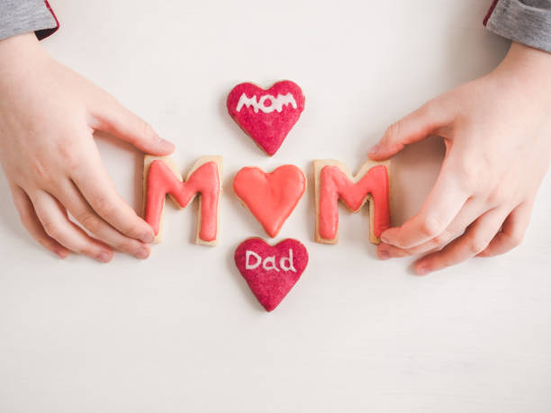 istock Hands of a younger daughter and word MOM 1133643780