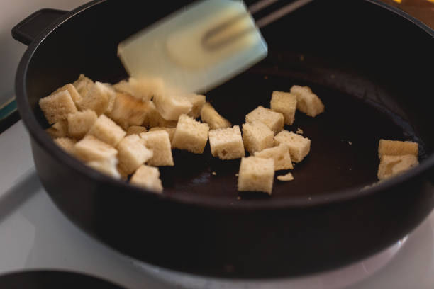 istock Croutons making, bread pieces dry toasting, close-up 1133644354