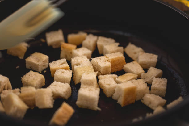 istock Croutons making, bread pieces dry toasting, close-up 1133644382