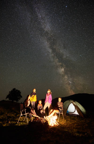 istock Friends beside camp, campfire, tents under night starry sky 1133645551
