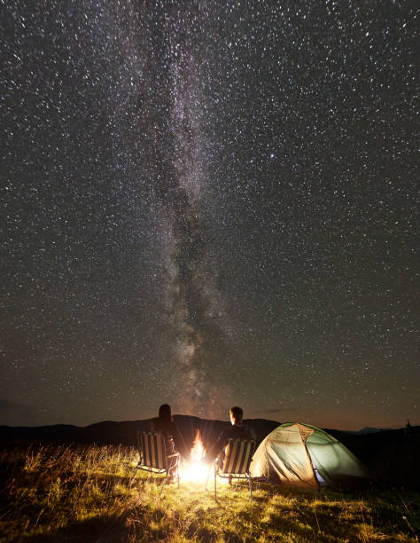 istock Couple tourists at night camp in mountains under starry sky 1133645563