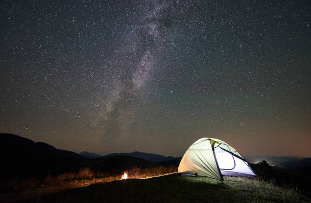 istock Tourist camping at night in the mountains under starry sky 1133645598