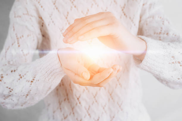 istock Light in young woman hands offering help, protection and support symbol. Sharing hope concept 1133645849