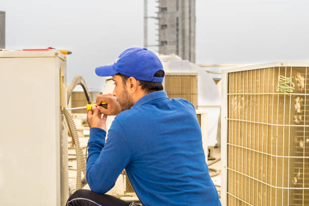 istock a professional electrician man is fixing a heavy duty unit of central air conditioning system by his tools on the roof top and wearing grey color of uniform and white cap 1133646041