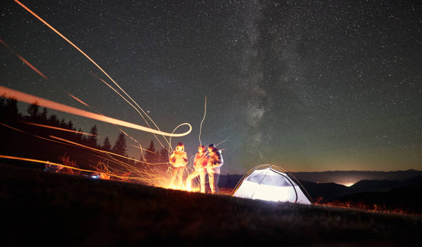 istock Friends resting beside camp, campfire under night starry sky 1133647162