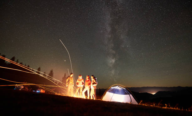 istock Friends resting beside camp, campfire under night starry sky 1133647163