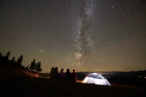 istock Friends resting beside camp, campfire under night starry sky 1133647166