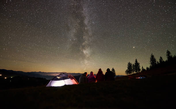 istock Friends resting beside camp, campfire under night starry sky 1133647167
