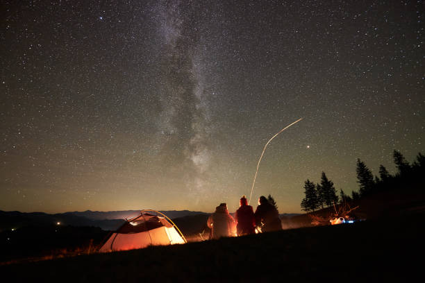 istock Friends resting beside camp, campfire under night starry sky 1133647176