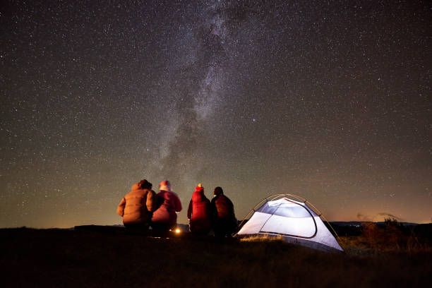 istock Friends resting beside camp, campfire under night starry sky 1133647178