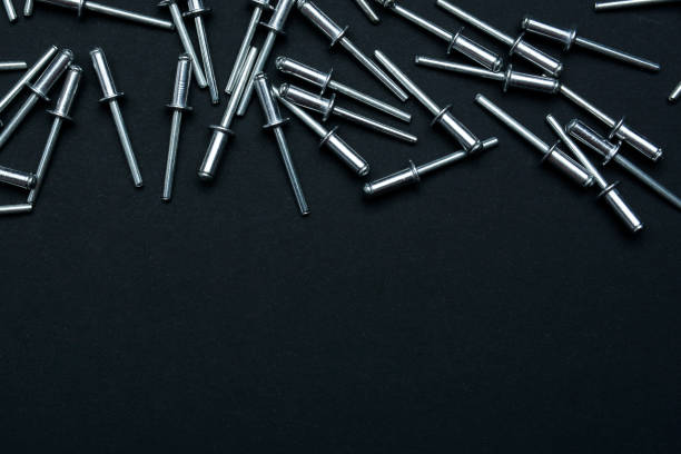 istock Metal rivets in black background. Falling rivets. Copy space for text. Vertical arrangement 1133647392