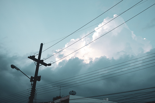 Electricity pole and light blue cloudy sky from low angle view