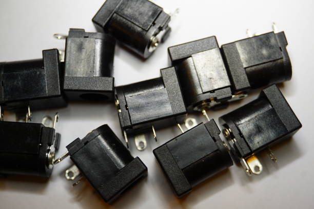 istock Close-up of scattered DC jack power electronics components on white background in random pattern 1133654783