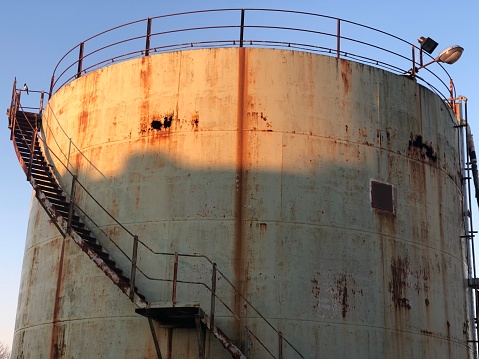 A dirty rusty oil storage tank