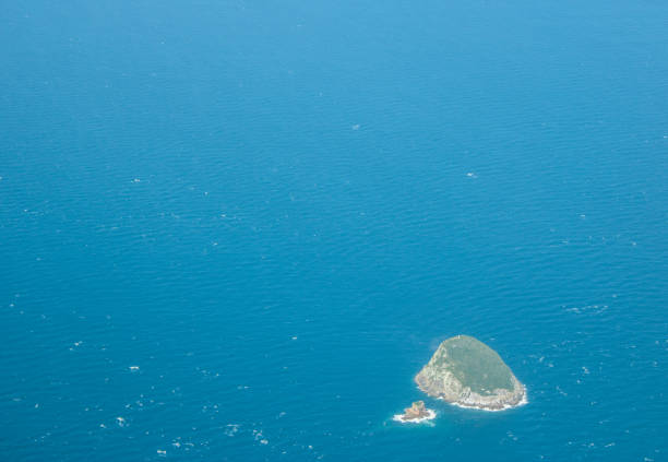 a small island stands in the ocean.