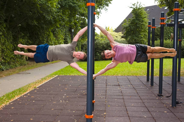 istock Two young men doing calisthenics exercises on bar outdoors. 1133660817