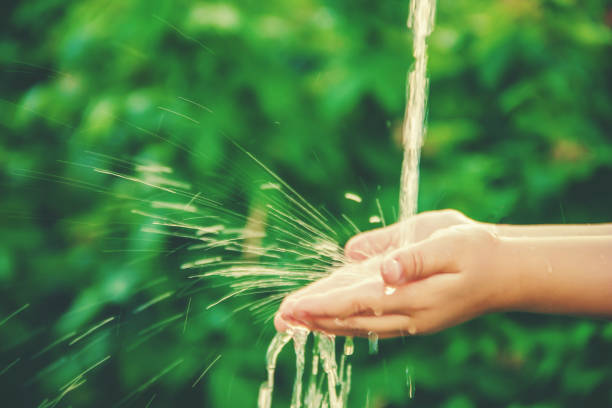 istock Water flows into the hands of the child. Selective focus. 1133663131
