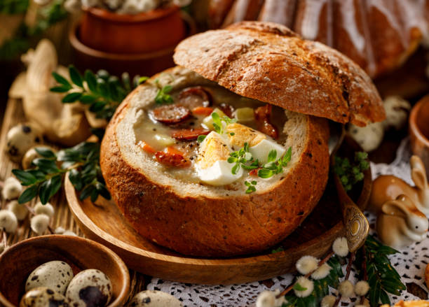 zuppa di pasqua, la zuppa acida (żurek) a base di farina di segale con salsiccia affumicata e uova servite in ciotola di pane. - polish bread foto e immagini stock
