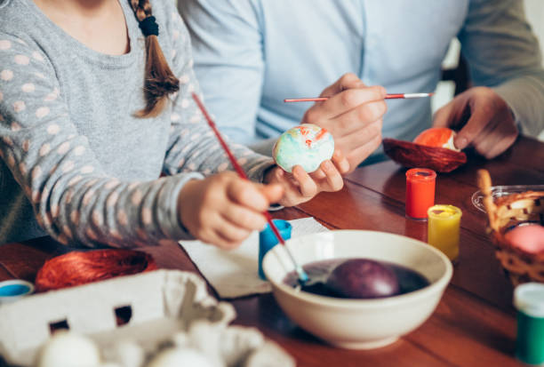 istock Happy family painting Easter eggs 1133667741